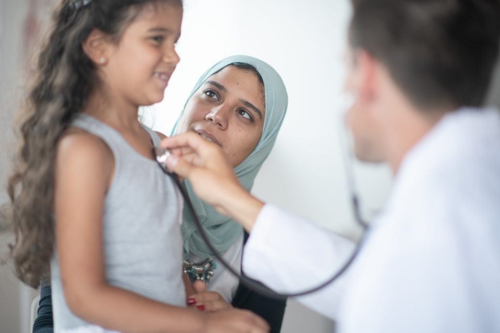 Young girl with her mom getting a medical check-up